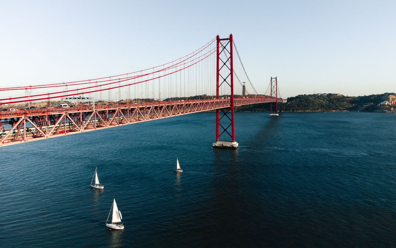 Panoramablick auf die Stadt Lissabon, mit dem Tejo-Fluss und mehreren Booten sowie der 25. April Brücke
