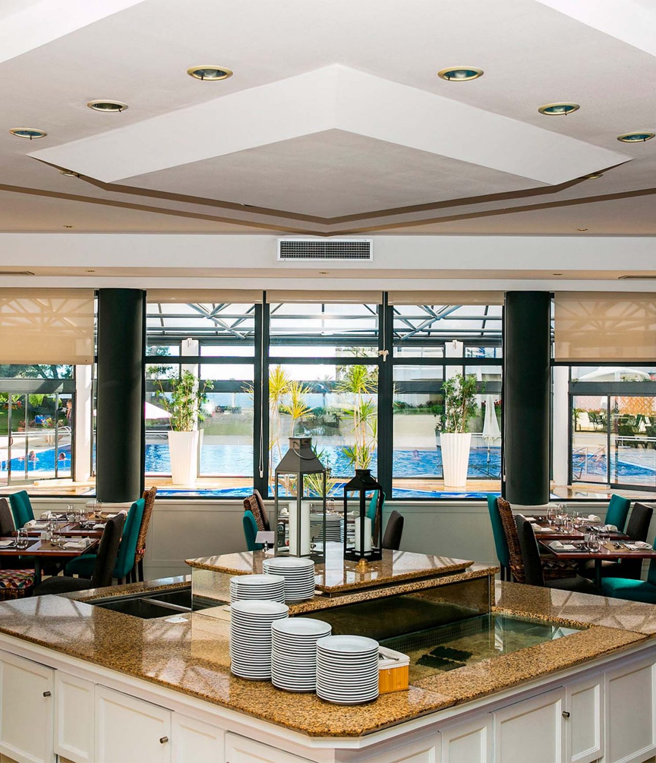 Das Restaurant Oceano im 4-Sterne-Hotel in Cascais hat mehrere Tische und Fenster mit Blick auf den Pool