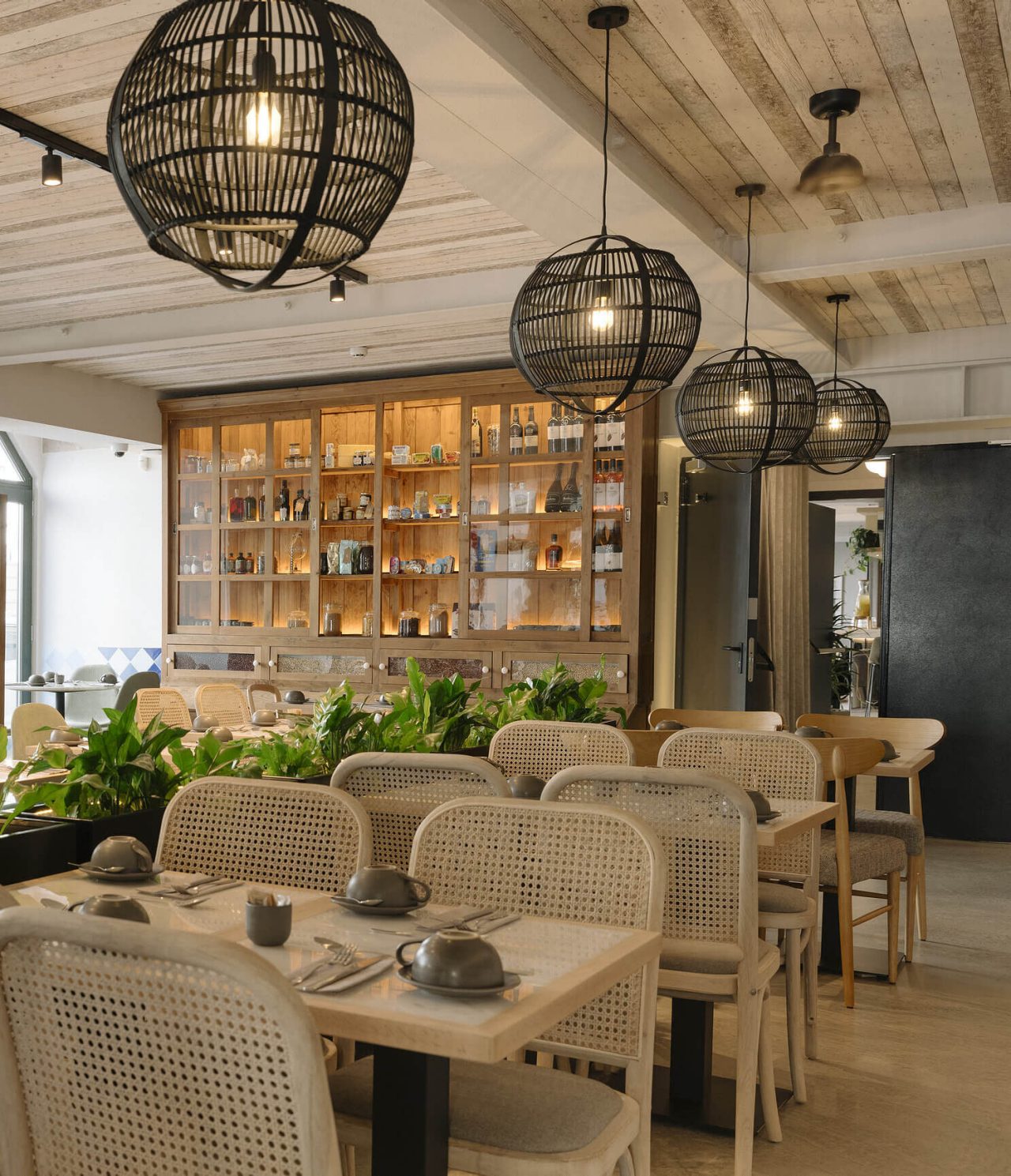 El restaurante Olive del hotel en el centro de Lisboa tiene varias mesas, plantas y decoración moderna