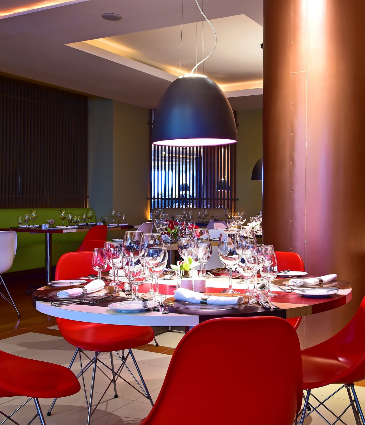 Das Restaurant Deep Blue im 4-Sterne-Hotel am Meer in Funchal hat einen runden Tisch mit roten Stühlen