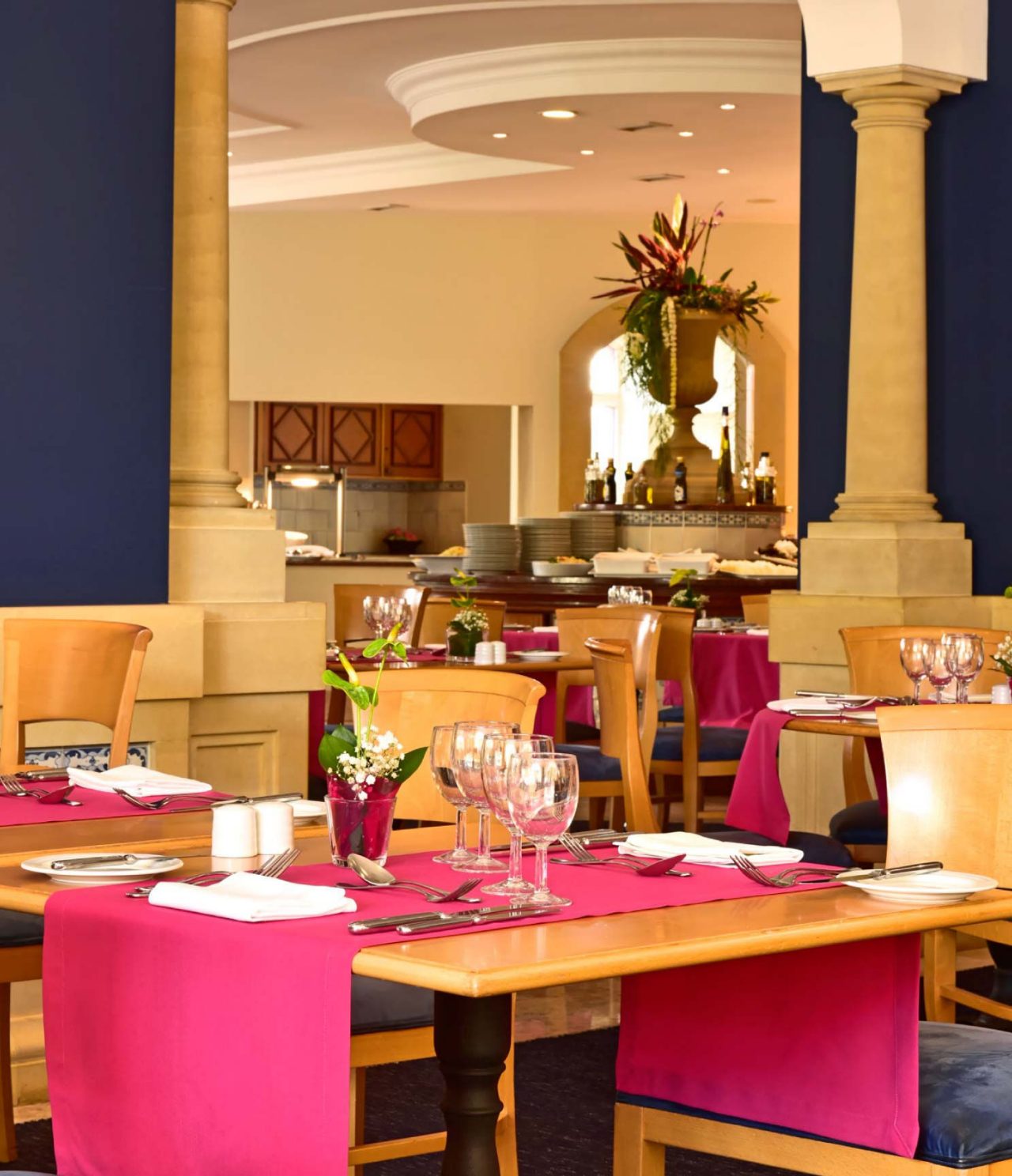 Das Restaurant A Vila, im Hotel de Charme auf Madeira hat mehrere Tische, mit einem roten Tischdecke und Blumen