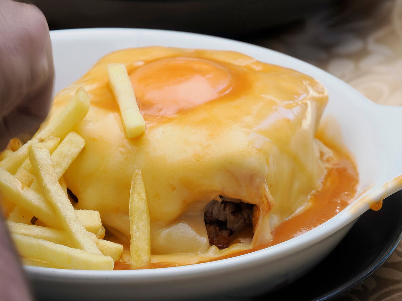 Typische Francesinha nach Porto-Art, berühmt für ihre Kombination aus Wurst, Brot, Fleisch und spezieller Soße