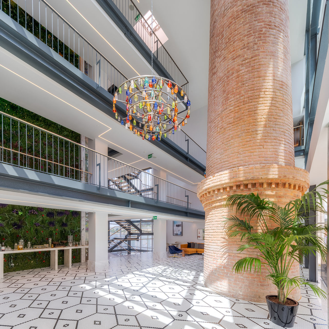Eingangshalle des Pestana Douro Riverside mit Ziegelkamin und buntem Glas-Chandelier