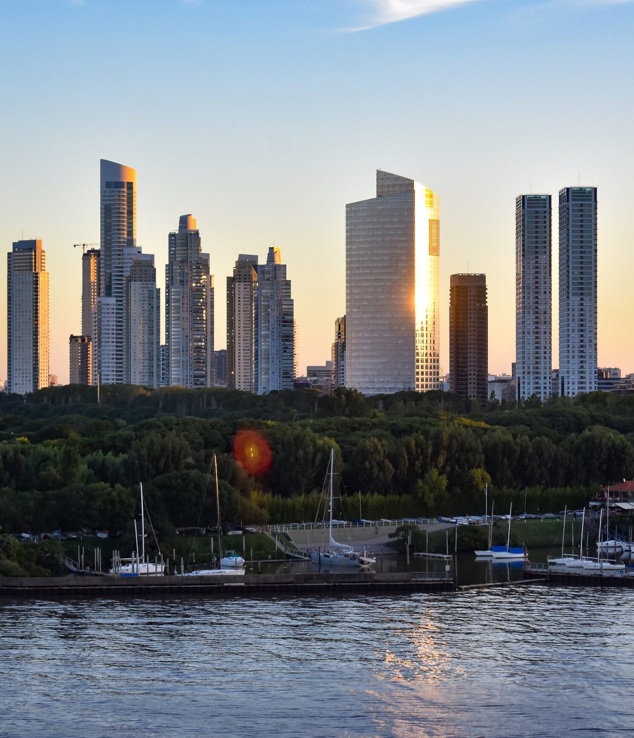 Blick auf die Skyline von Puerto Madero in Buenos Aires, mit modernen Gebäuden und Sonnenuntergang im Hintergrund