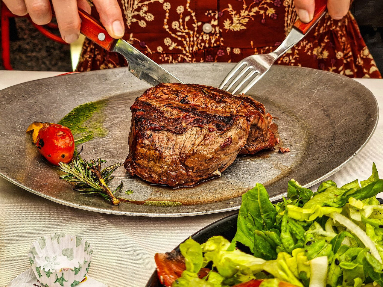 Typisches argentinisches Gericht, bestehend aus Rindfleisch, serviert mit einem Salat aus Kopfsalat und Tomaten