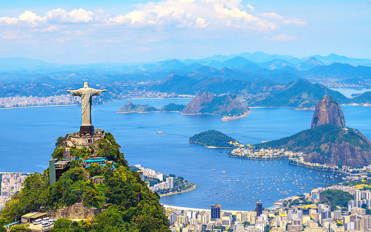Ikonische Statue des Christus-Erlösers in Rio de Janeiro, mit der Stadt, dem Ozean und dem Strand im Hintergrund
