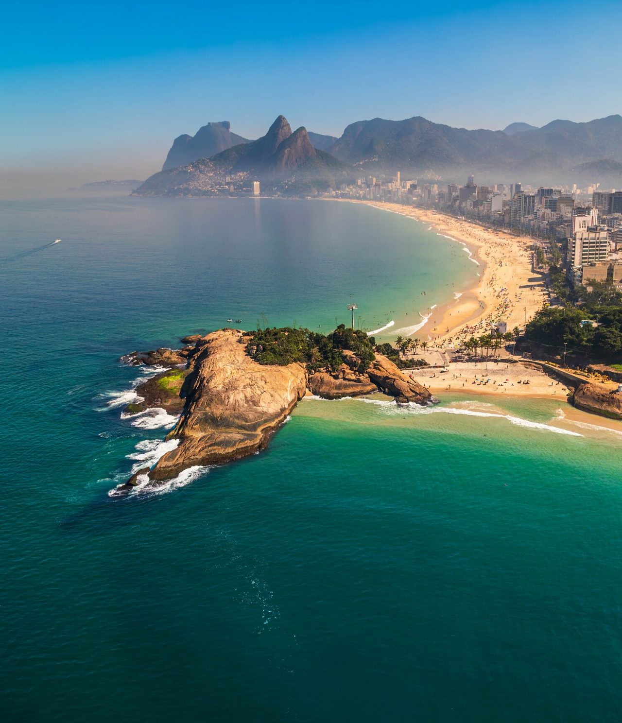 Luftaufnahme von Rio de Janeiro, mit Bergen im Hintergrund, weißem Sandstrand und türkisblauem Meer