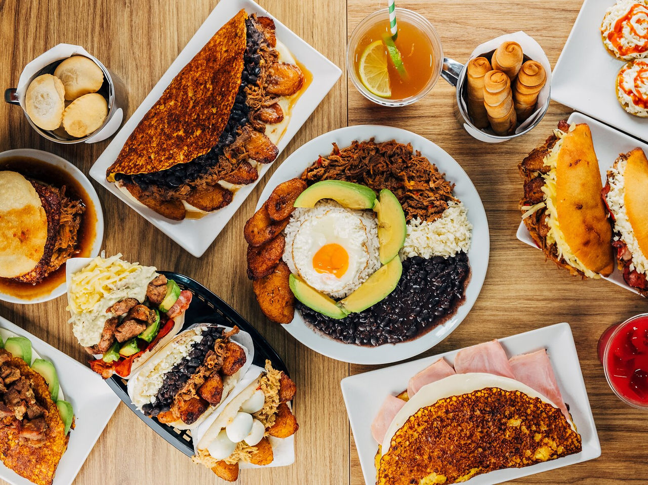  Tisch voller typischer venezolanischer Gerichte, darunter Arepas, Tequeños und Chapachas