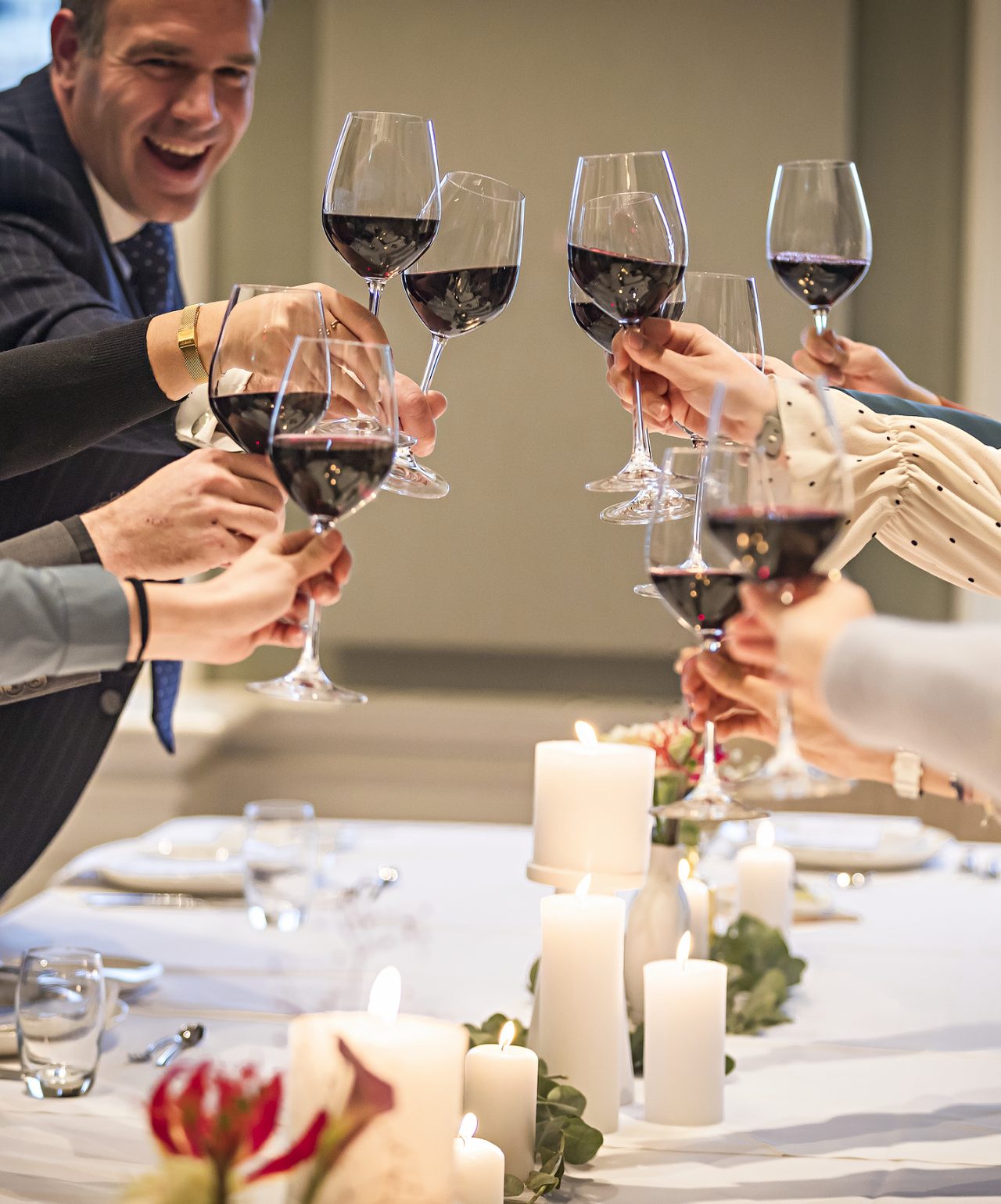 Gäste stoßen mit Gläsern Rotwein bei einer Hochzeit mit eleganter Dekoration im Pestana Hotel Group an