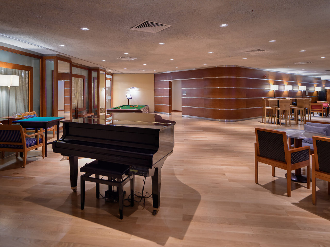 The Prime bar, at the 5-Star Hotel in Vilamoura, has a spacious area with tables, chairs, and a piano