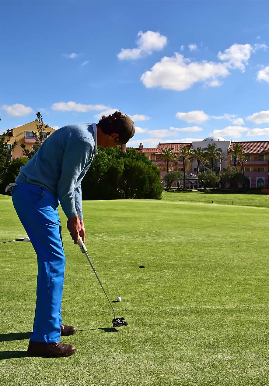 On a green golf course a man about to take a shot focused with perfect posture