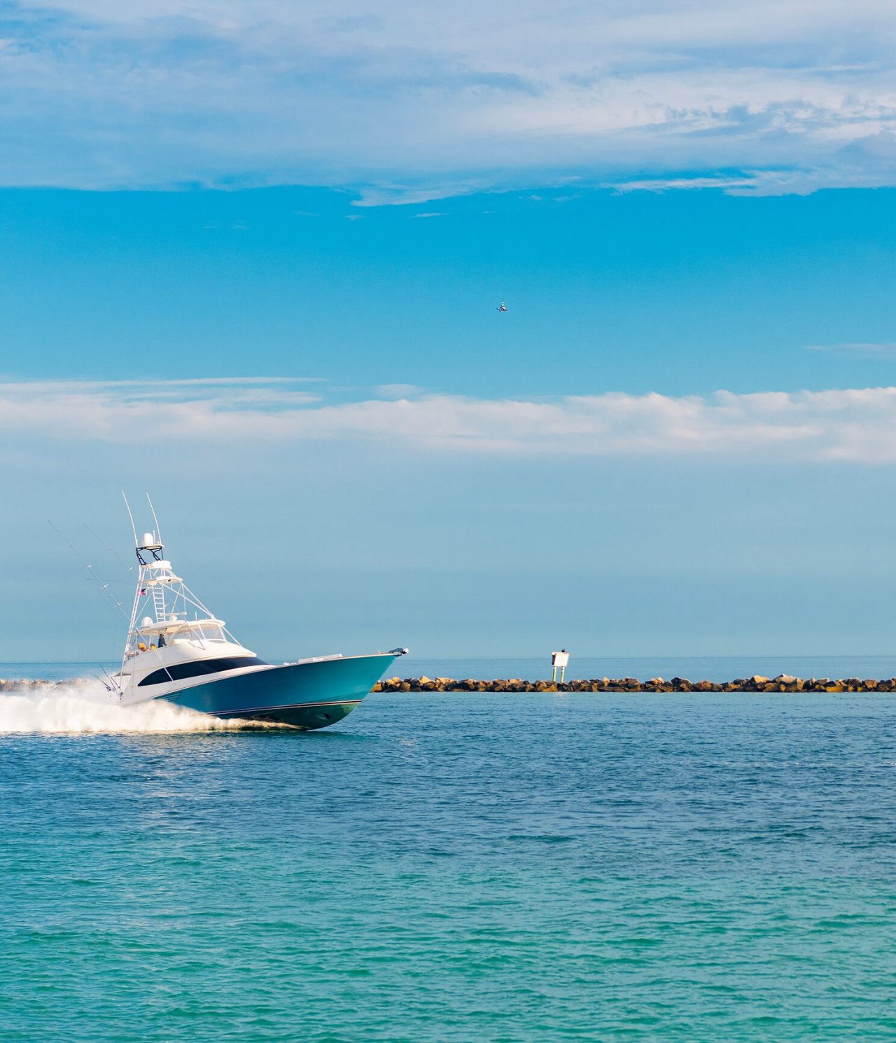 Barco azul y blanco entrando en el muelle de Miami sobre agua azul cristalina