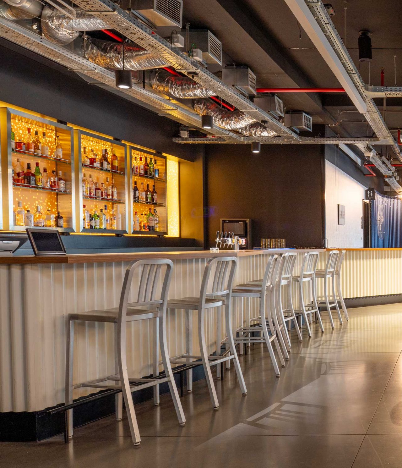 El bar del hotel en Bruselas cerca del Parlamento Europeo tiene una barra con taburetes altos y mesas redondas con sillas