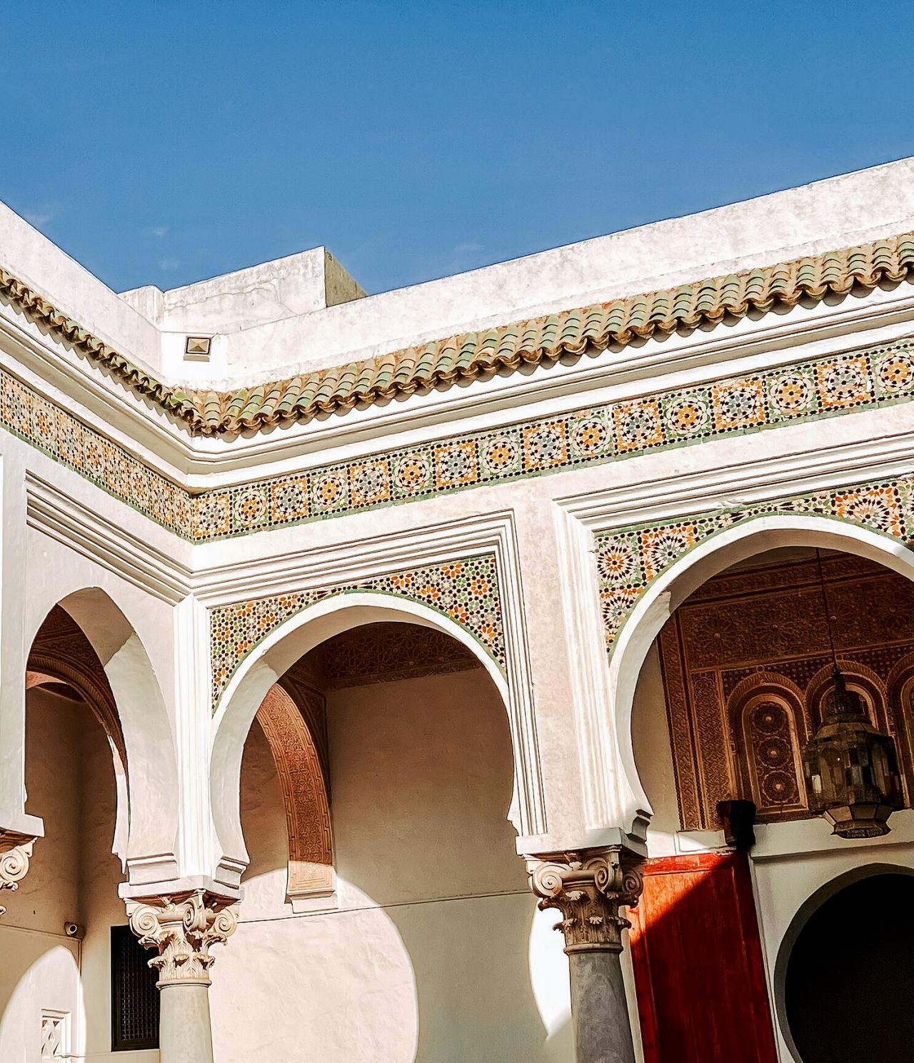 Patio intérieur d'un bâtiment traditionnel marocain, avec plusieurs motifs symétriques et colorés sur les murs