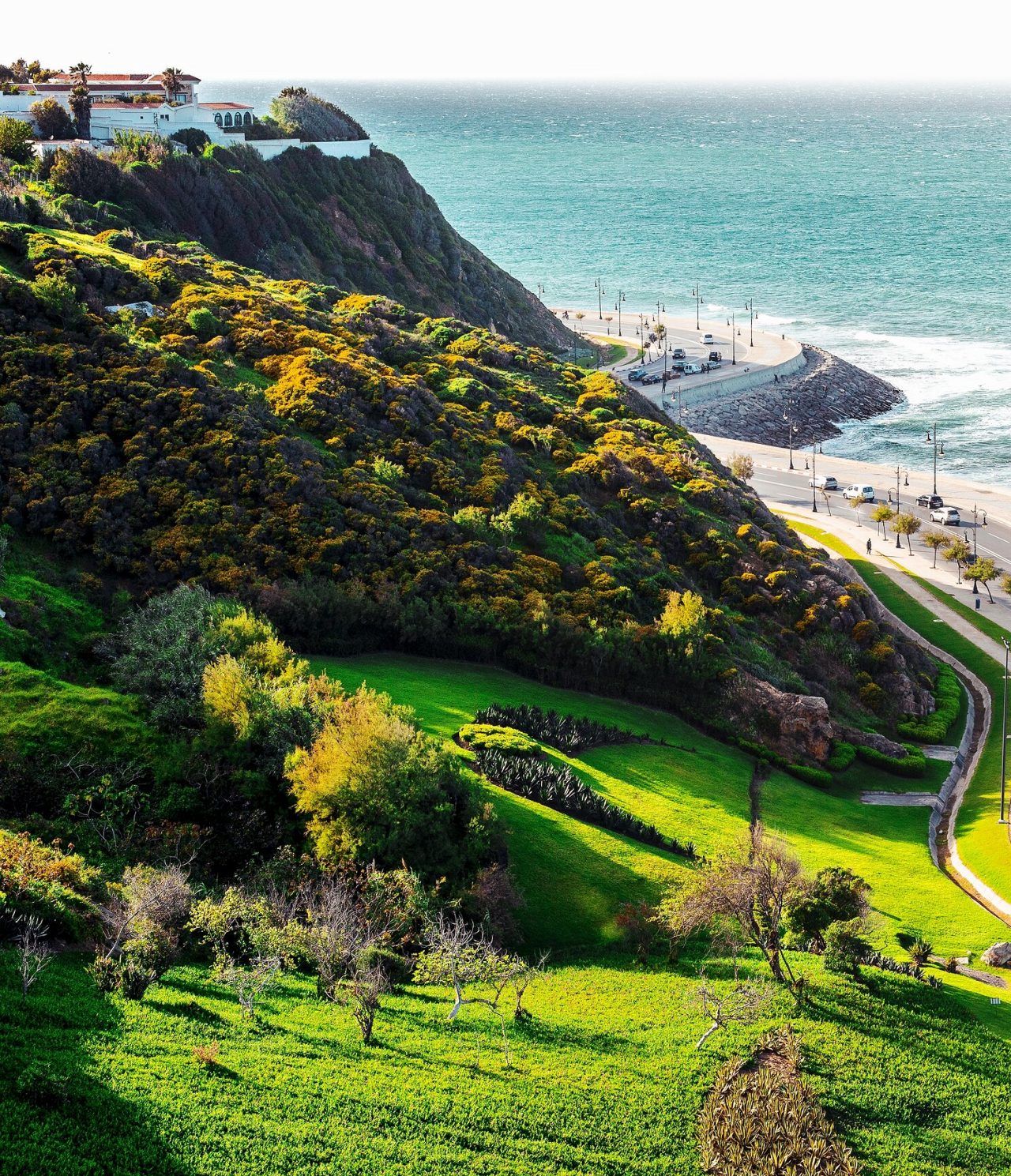 Route côtière à Tanger, où les voitures roulent près de la mer avec vue sur les vagues et l'horizon