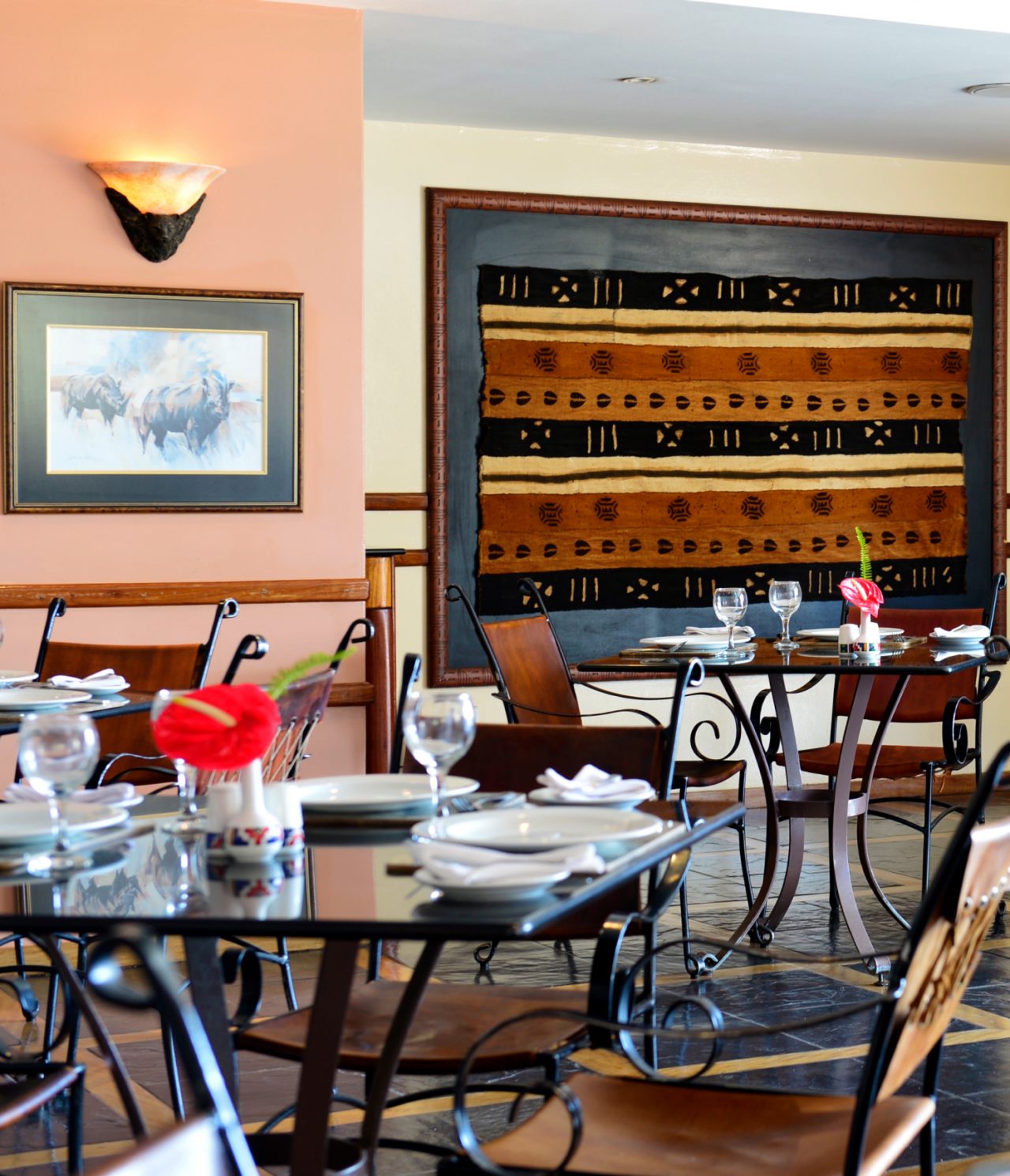 Le restaurant Monomotapa, de l'hôtel 4 étoiles à Maputo, a tables avec fleur rouge et chaises