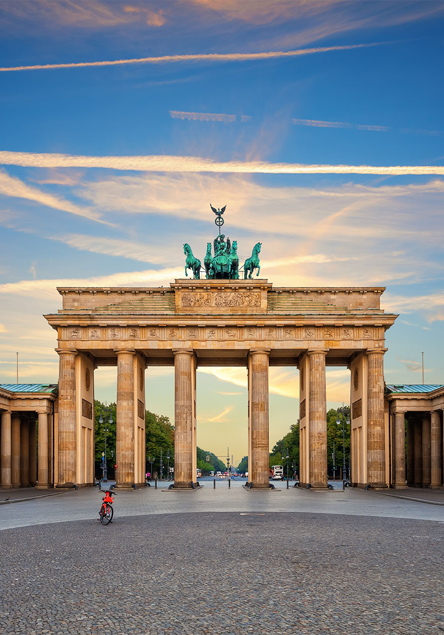 Vue de la porte de Brandebourg à Berlin, par un jour de ciel clair avec peu de nuages et un vélo au milieu du pavé