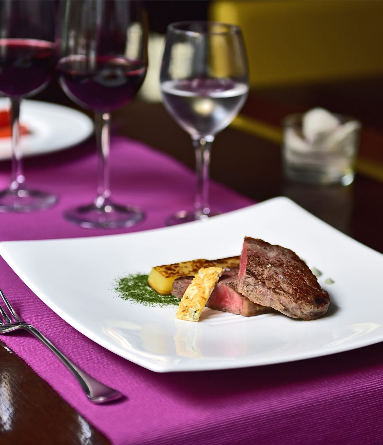 Le bar Lobby de l’hôtel à Barcelone a un plat élégant avec viande et fruits, et un verre de vin et d’eau