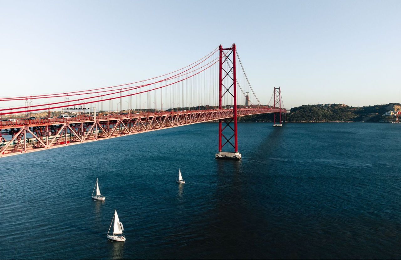 Vue panoramique de la ville de Lisbonne, avec le fleuve Tejo, plusieurs bateaux et le pont du 25 Avril