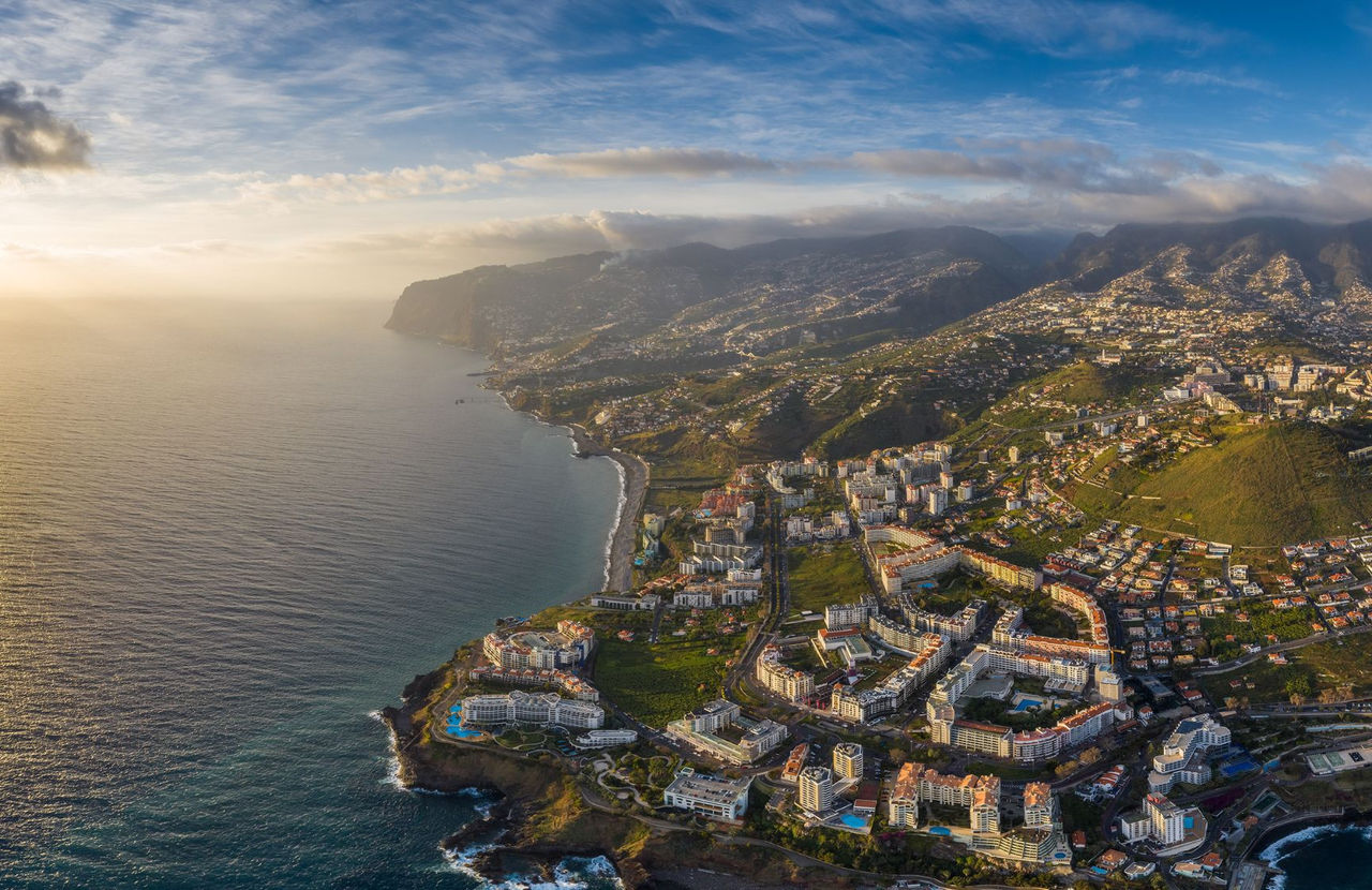 Vue aérienne de la ville de Funchal, à Madère, avec des zones urbaines denses et des montagnes en arrière-plan