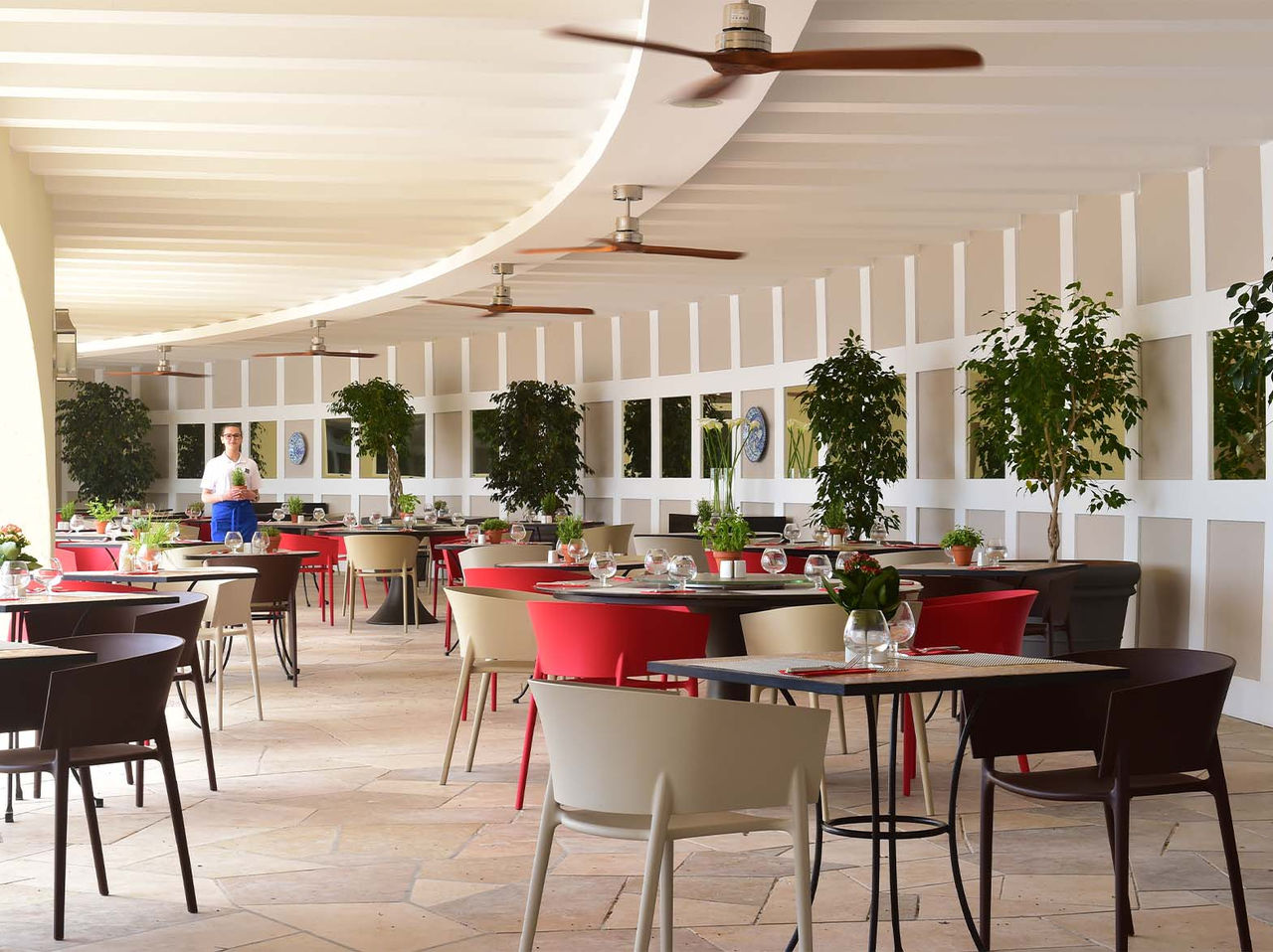 Le bar Oceano de l’hôtel 5 étoiles en Algarve a une terrasse extérieure avec de petits arbres et des chaises colorées