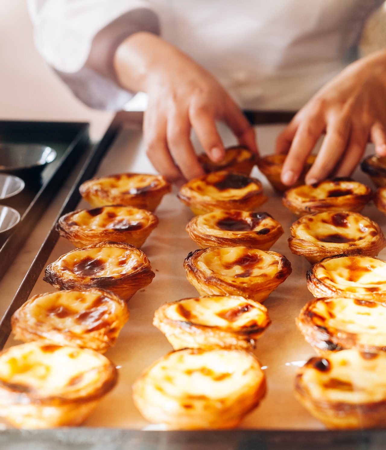 Chef démoulant des pastéis de nata, une pâtisserie typique du Portugal et de Lisbonne