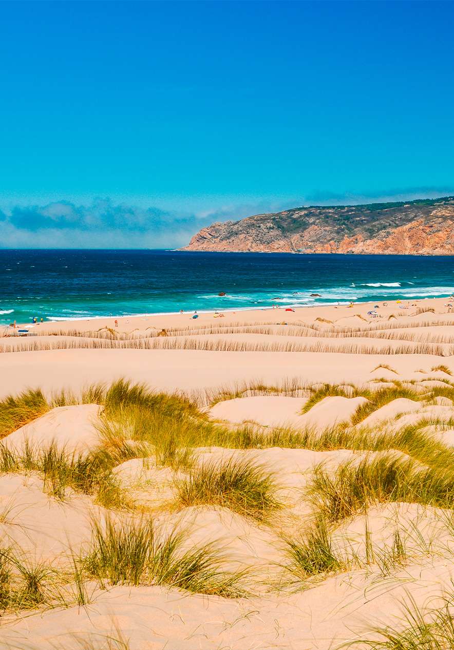 Plage do Guincho à Cascais, avec un jour parfait, du sable doré, des dunes et la mer bleue