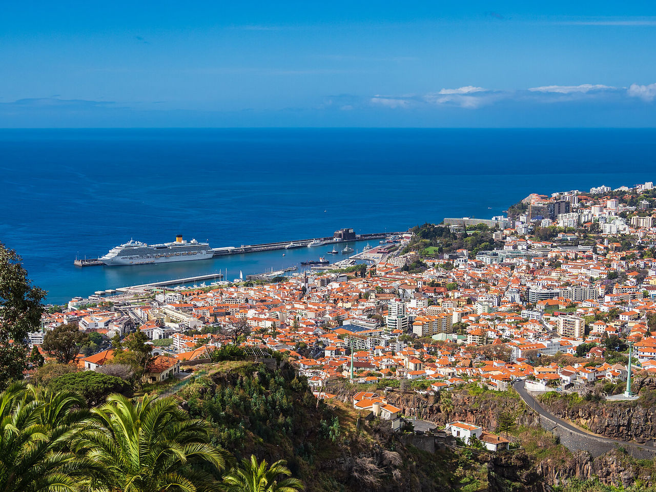 Vue sur la ville de Funchal, pleine de couleurs et au bord de la mer, avec un bateau de croisière en arrière-plan