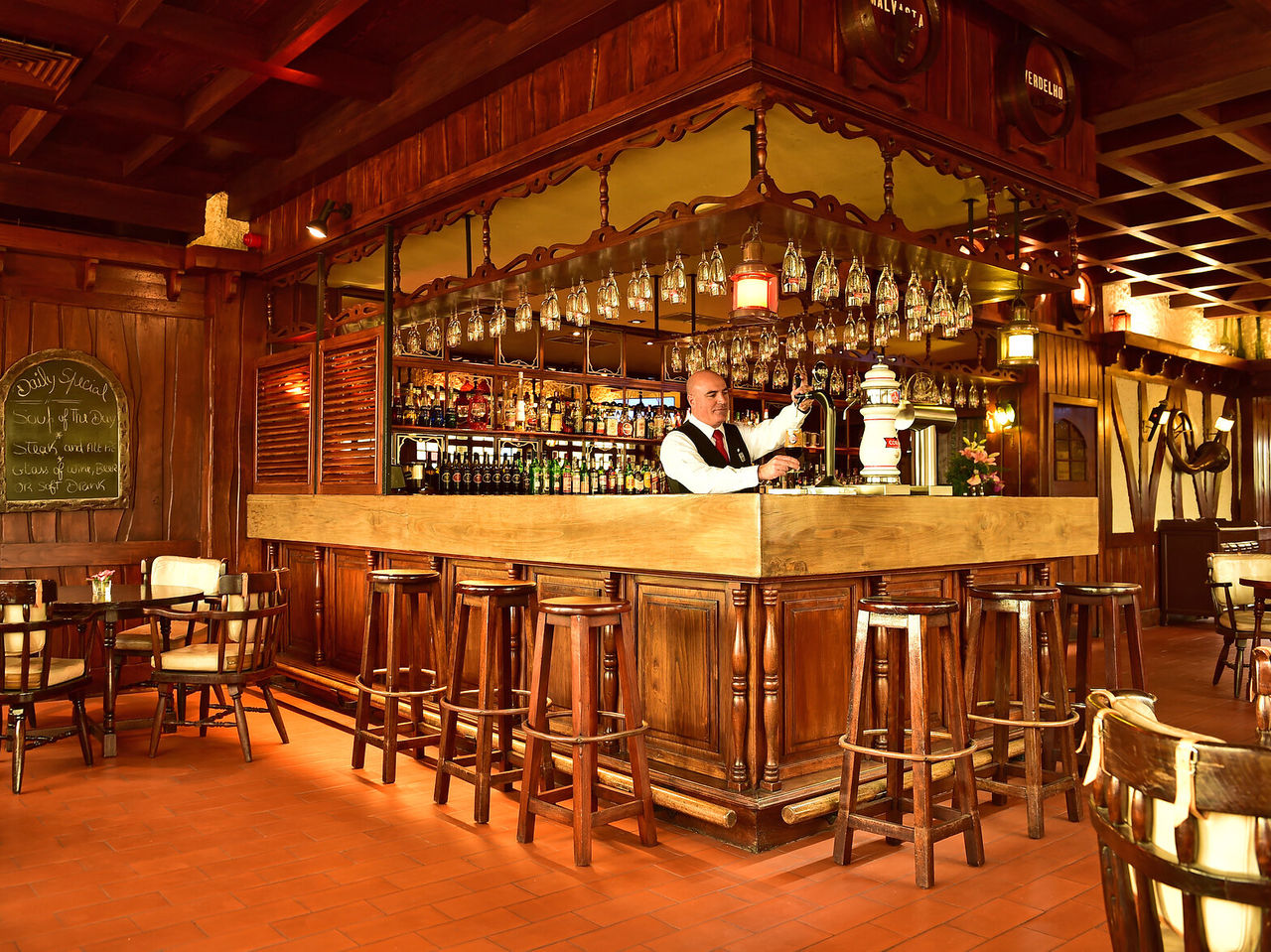 Le bar The Pub, de l'hôtel au centre de Funchal, Madeira, a un comptoir entouré de tabourets hauts et diverses boissons