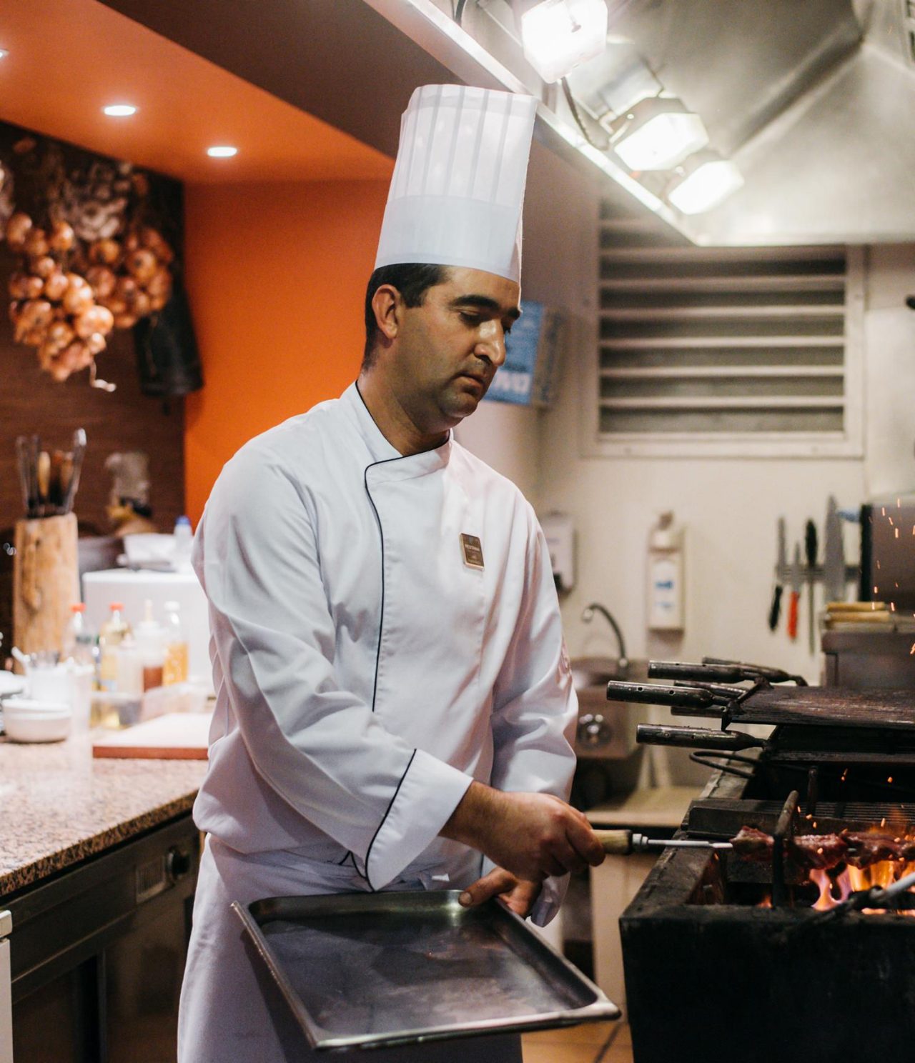 Le restaurant Adega Madeirense, de l'hôtel 4 étoiles au centre de Funchal, a un chef grillant la viande au barbecue