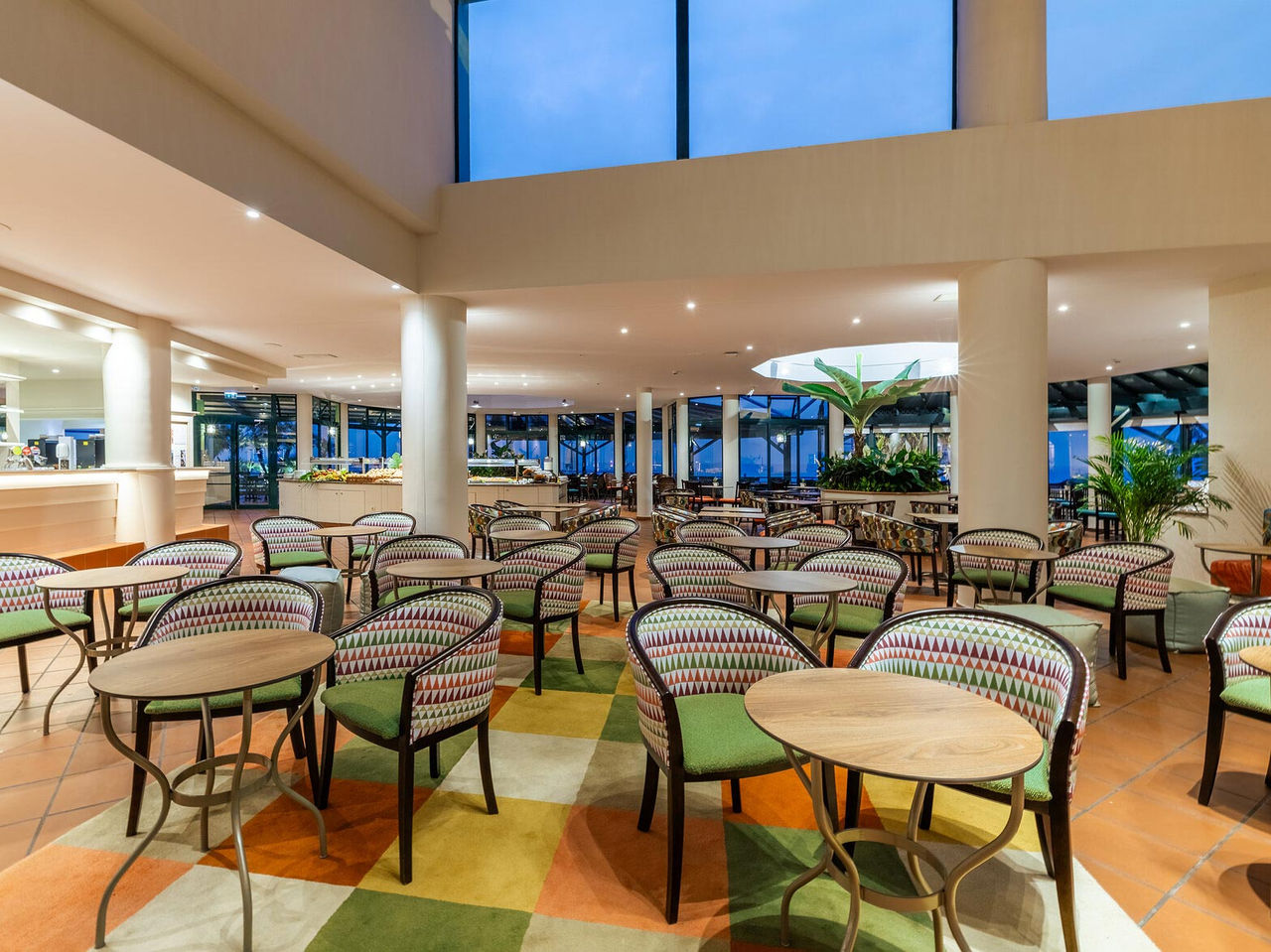 Le bar Arlequim de l'hôtel 5 étoiles à Funchal, à Madère, dispose de chaises avec des tables rondes et une moquette