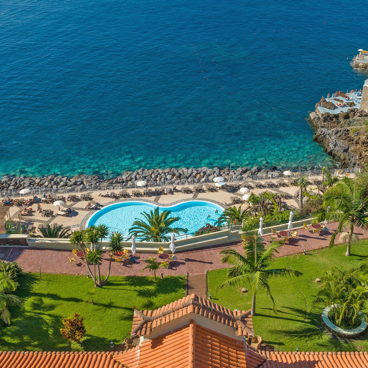 Vue aérienne du Pestana Vila Lido Madeira, avec vue sur la mer, des palmiers autour et une piscine