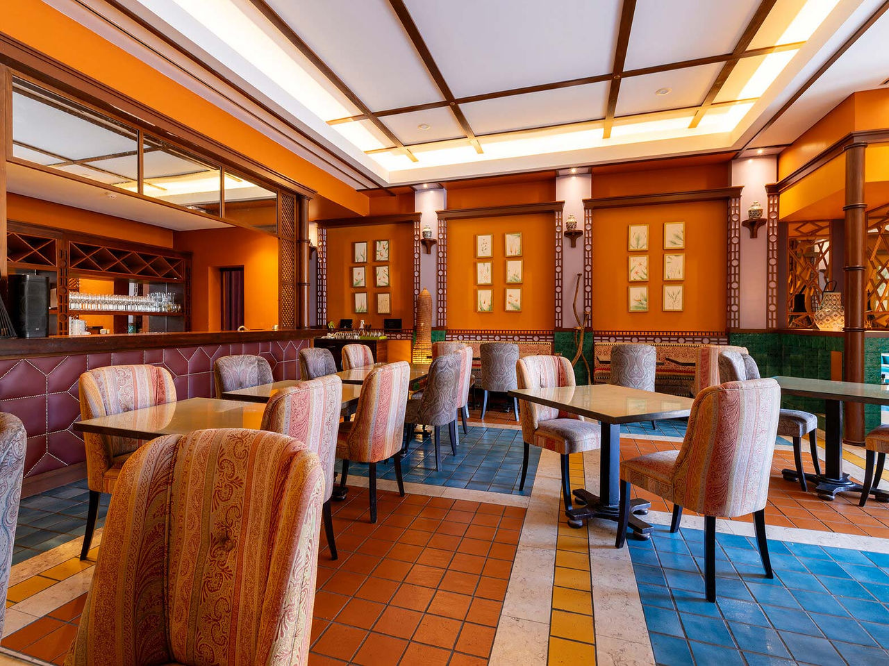 Le restaurant Arab Magrebe du Resort 5 étoiles à Porto Santo propose des tons chauds, des tables carrées et des chaises rembourrées.