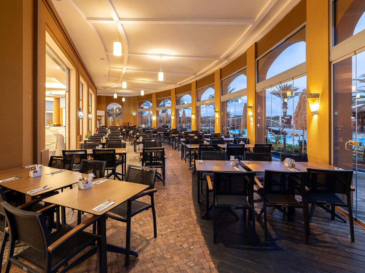 Le restaurant Marés du Resort 5 étoiles à Porto Santo dispose d’un espace extérieur avec des tables carrées et des chaises.