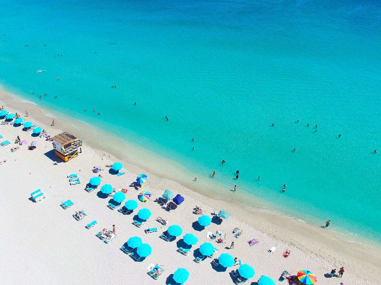 Plage de Miami Beach, Floride, avec du sable blanc, de l'eau turquoise et des personnes nageant et bronzant