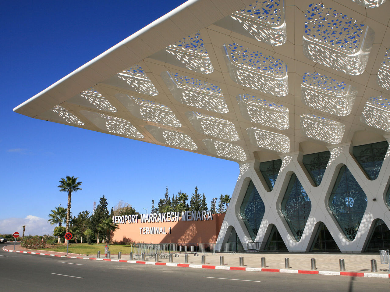 Land op de luchthaven van Marrakesh, een grote moderne structuur in witte tinten
