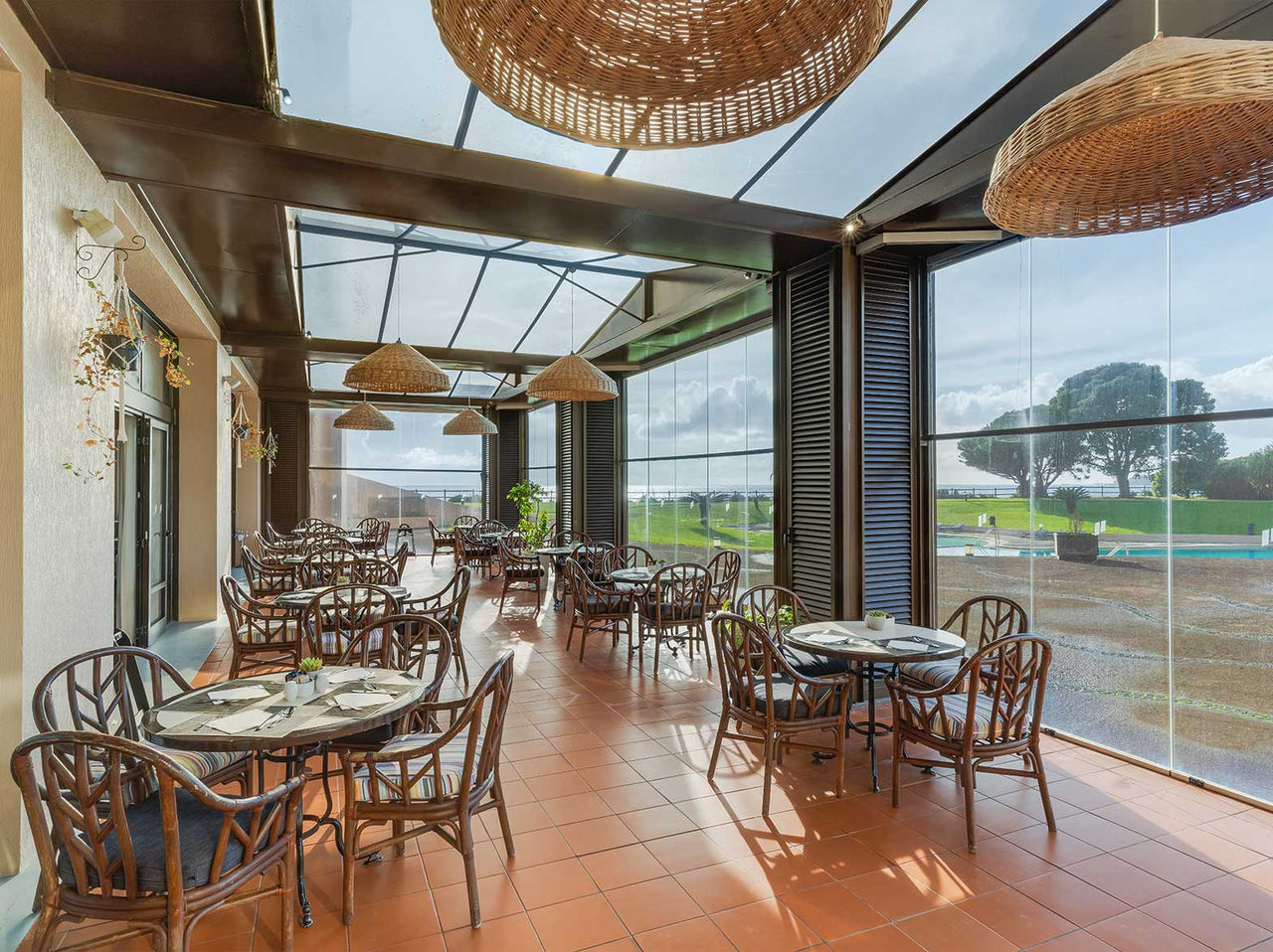 Het restaurant Lugar da Praia, van het 4-sterrenhotel op de Azoren, heeft een overdekte veranda met uitzicht op het zwembad