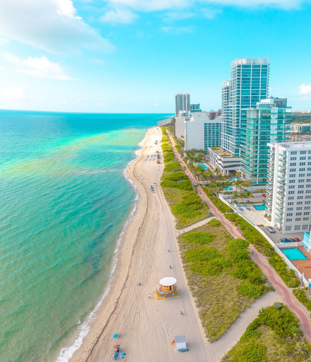 Luchtzicht op het beroemde strand van Miami, omgeven door een fietspad en hoge woon- en kantoorgebouwen