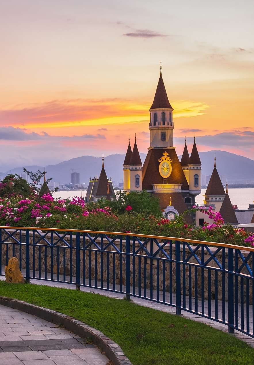 Panoramisch uitzicht op een Disney-kasteel in een themapark in Orlando, met een meer en bergen op de achtergrond