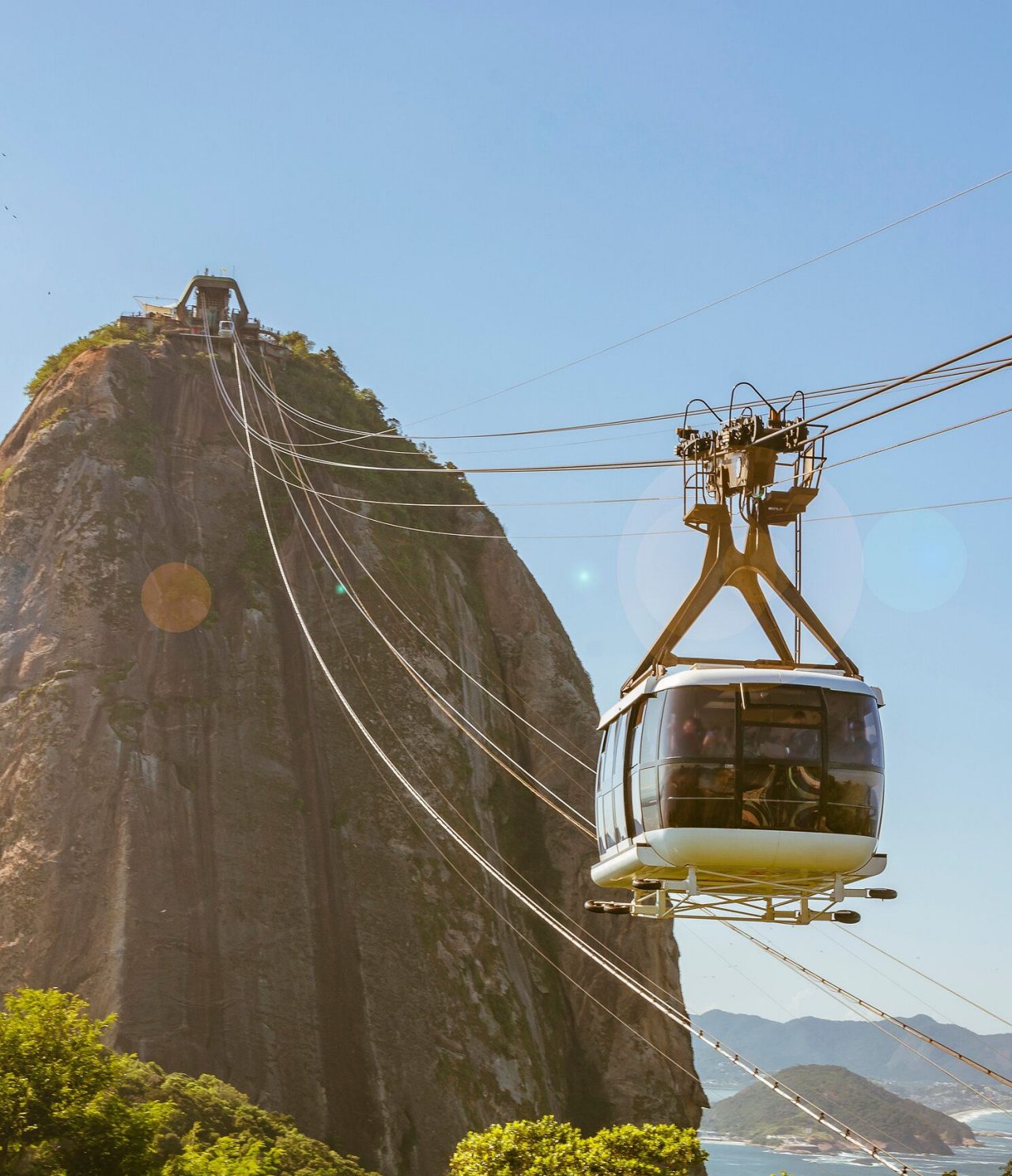 Uitzicht op de kabelbaan in Rio de Janeiro, richting een hoge heuvel, met de zee op de achtergrond