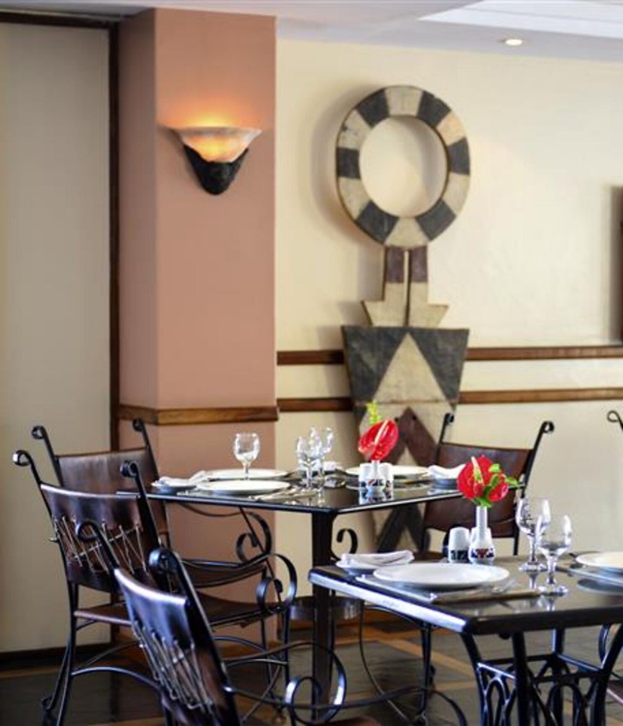 O restaurante Piazza del Campo, do Hotel 4 Estrelas em Maputo, tem mesas e cadeiras pretas e arte nas paredes