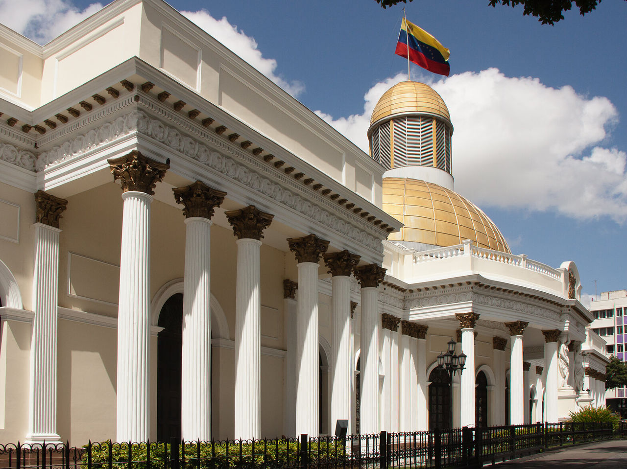 Imponente fachada do Palácio Federal Legislativo em Caracas, com colunas brancas e uma cúpula dourada