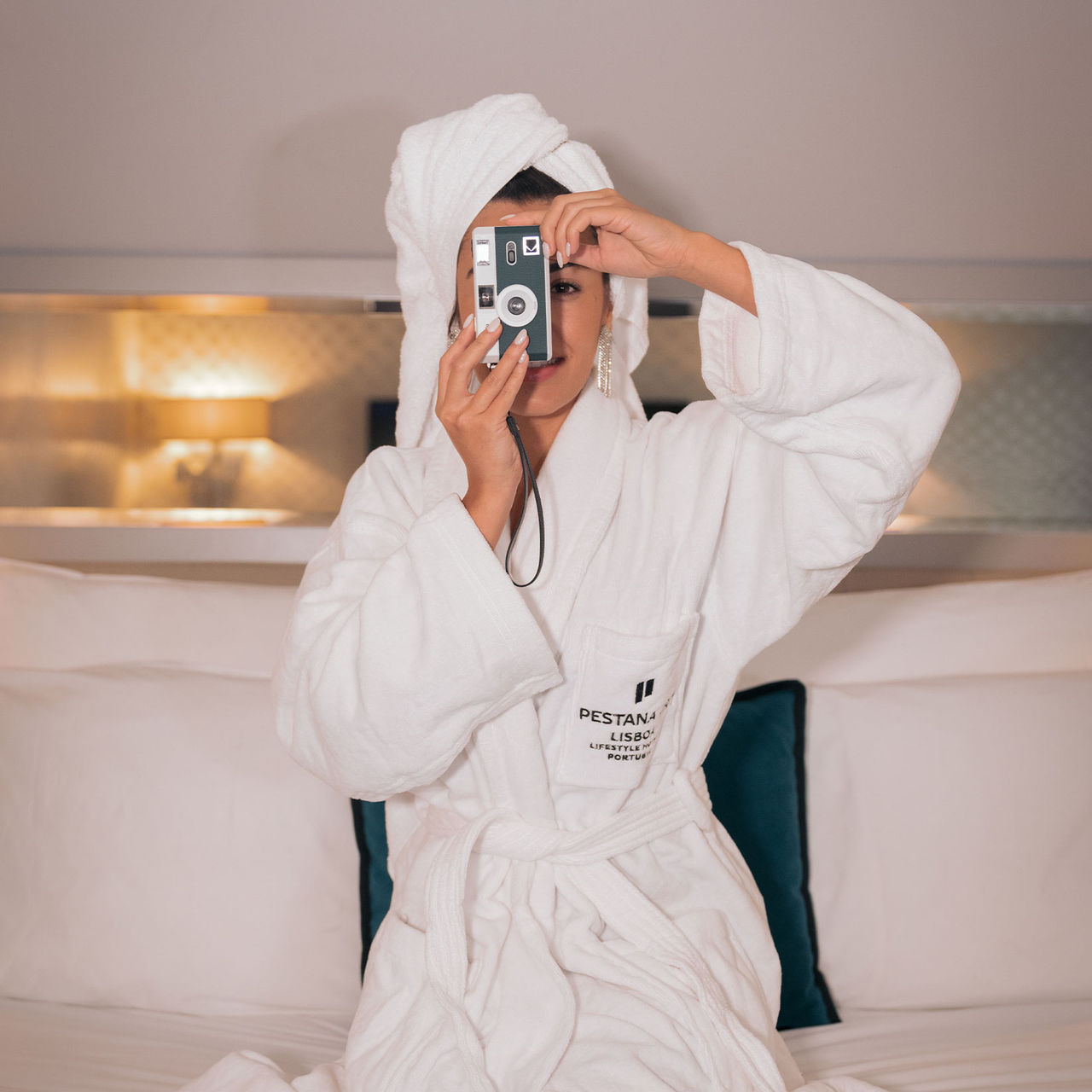 Rapariga tira uma fotografia com máquina digital num quarto do Pestana CR7 Lisboa