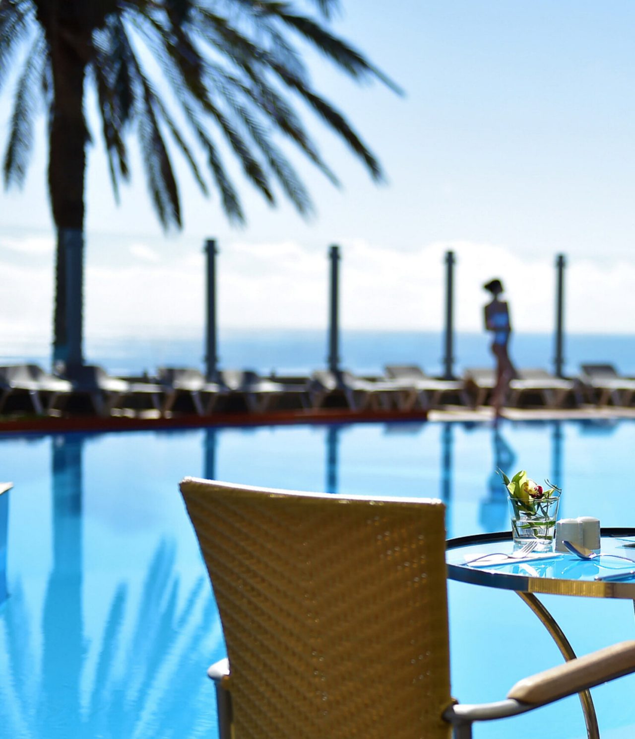 O Pool Bar, do Hotel 5 Estrelas no Funchal, na Madeira, tem um bar exterior com vista para a piscina e mesa com cadeiras