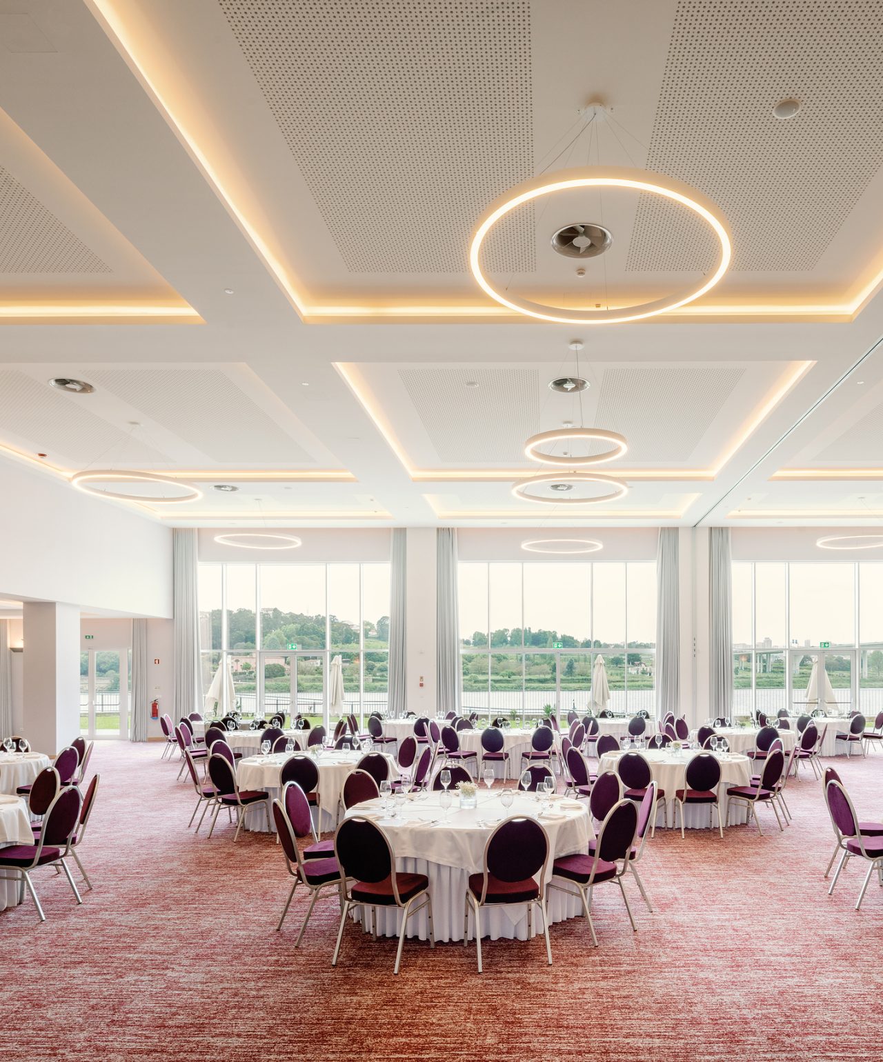 Reuniões e Conferências no Pestana Hotel Group, em salas amplas e elegantes, com várias mesas redondas e luz natural