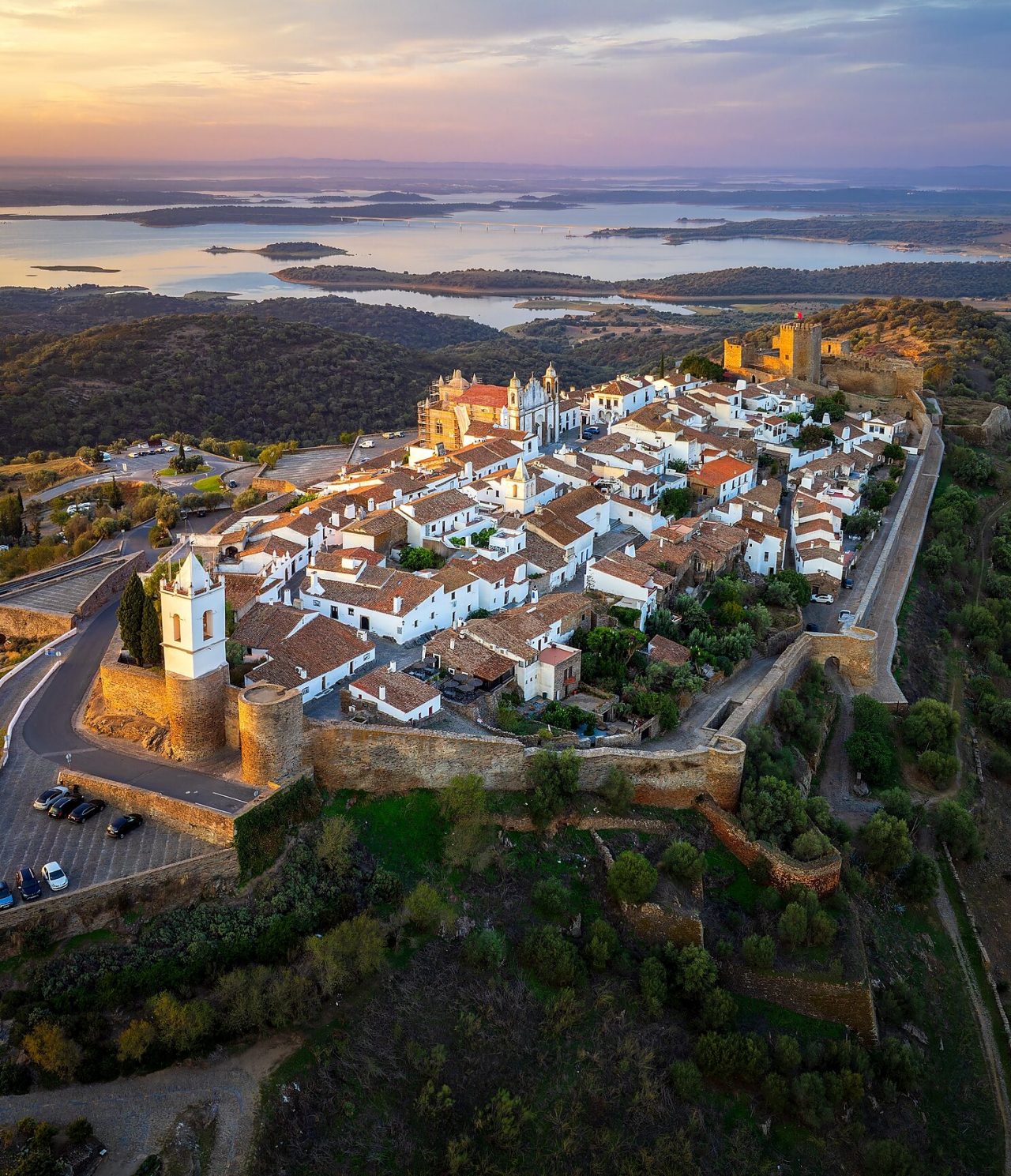 Aerial view of Monsaraz hill in Alentejo at sunset, with a castle, a cathedral, and the village