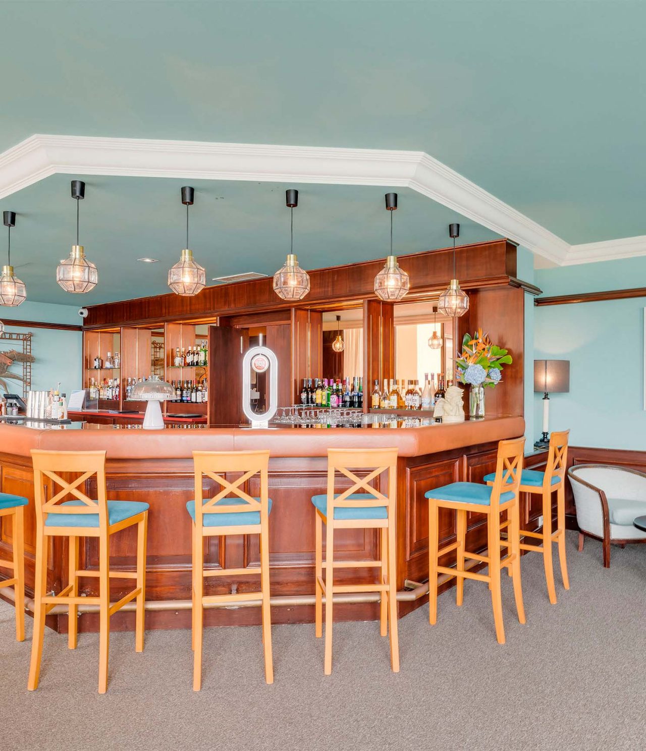 Aqqua bar has a wooden counter with chairs to order drinks